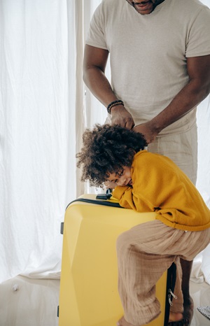 Ready to travel: child sitting on a suitcase