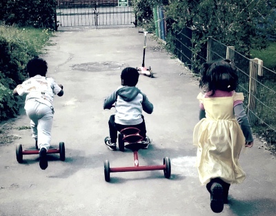 Kids on bicycles playing outdoors in Manchester Montessori House