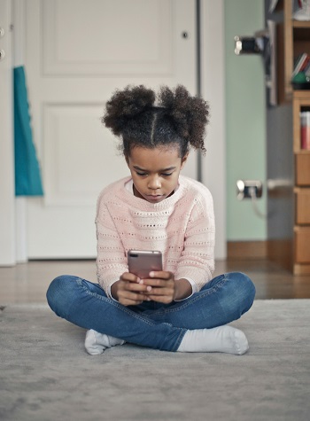 Girl with smartphone sitting on the floor | photo Bruce Mars